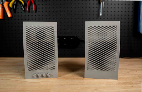 Pair of grey Mid90s desktop speakers with grilles and amplifier controls